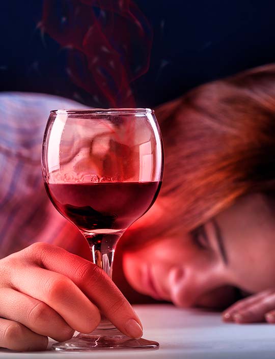 Женщина лежит на столе с бокалом вина в руках
